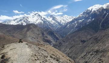Vast mountainous landscape with snowy peaks under a clear sky.
