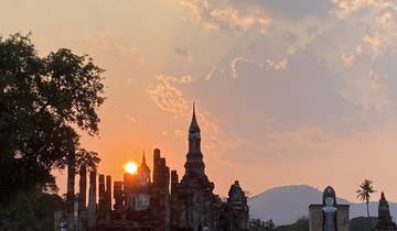 Ancient temple ruins with a sunset backdrop.
