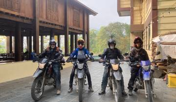 Four motorcyclists posing in front of a building