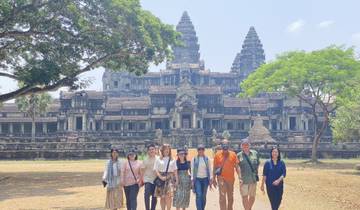 Group of people standing in front of a temple-like ancient structure.
