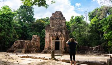 Person photographing an ancient stone temple.