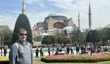 Tourist standing in front of a large historic mosque.