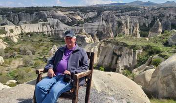 Person sitting with a view of Cappadocia's rock formations.