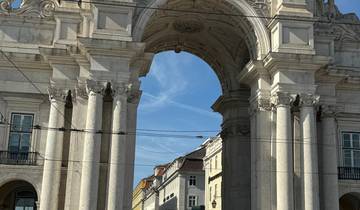 Arch at famous Portuguese square bustling with people.