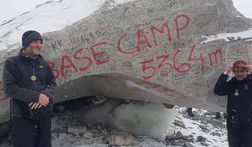 Two people at the base camp in snowy conditions.