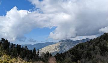 Mountain range with a dramatic sky featuring clouds and sunlight.
