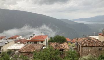 Scenic mountain village with red-tiled roofs and mist.