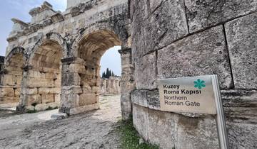 Ancient Roman gate with a sign in the foreground.