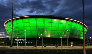 Illuminated modern arena at dusk with 'The OVO Hydro' signage.