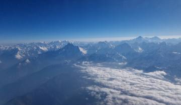 Panoramic view of snow-covered mountain range with clouds.