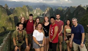 Group of people posing with limestone karst hills in the background.