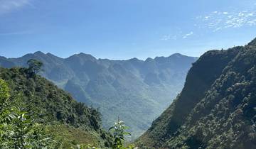 Mountainous landscape with clear blue sky and lush greenery.