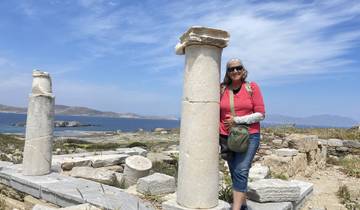Woman posing next to ancient ruins with a sea view on Delos.