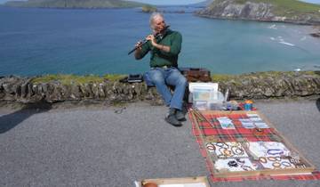 Man playing flute near coastal view.