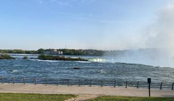 View of Niagara Falls from a distance with mist rising.