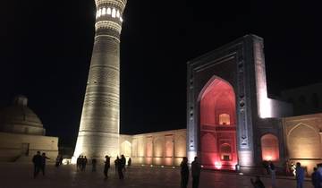 Mosque and minaret lit up at night.