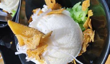 Dessert with coconut ice cream and toppings in a bowl.