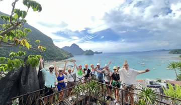 Group of tourists posing with a scenic bay view behind.