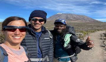 Three people posing with a mountain in the background.