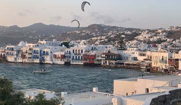 Coastal town with white and colorful buildings by the sea.