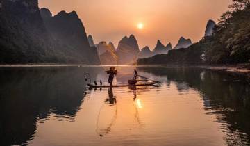 A fisherman casting a net at sunset in Yangshuo.