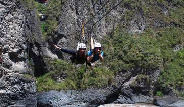 Two people ziplining over a canyon.