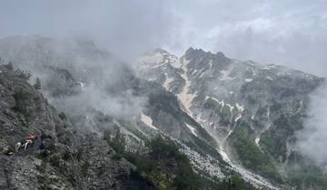 Misty mountainous landscape with patches of snow.
