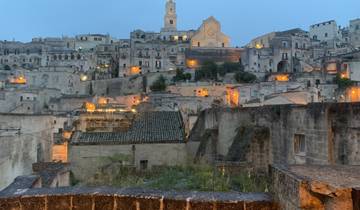 Cityscape of Matera with illuminated buildings at dusk.