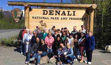 A large group of people posing in front of a Denali National Park sign.
