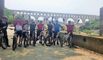 Cyclists posing in front of the Pont du Gard aqueduct.