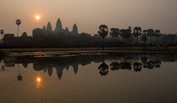 Angkor Wat silhouette at sunrise with reflections.