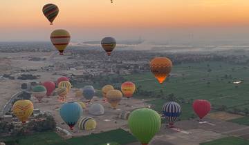 Multiple hot air balloons in the sky at dawn.