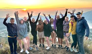 Group at sunrise with scenic view and joyful expression.