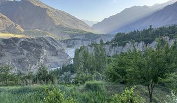 A lush valley with dramatic cliffs and trees.