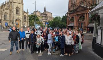 Group photo of tourists in a vibrant city street.