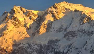 Golden light illuminating snowy peaks at sunset.