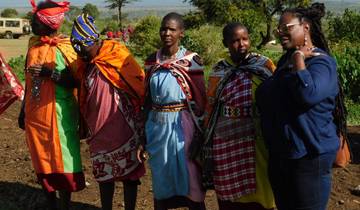Women in traditional Maasai attire standing outdoors.