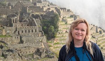 Woman smiling with Machu Picchu ruins in the background.