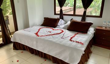Bed decorated with rose petals spelling 'LOVE'.