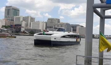 Boat cruising on a river with city buildings in the background.