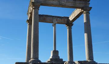 Ancient stone columns standing against a clear blue sky.