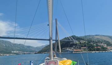 A bridge seen from a sailing boat with a mountainous background.