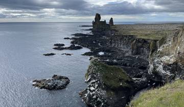 Cliffside with rock formations overlooking the ocean.
