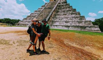 Two people playfully posing in front of an ancient pyramid.