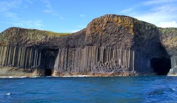 Dramatic basalt columns and caves on the shore.