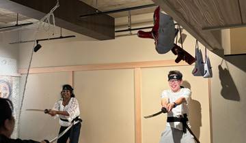 Two people practicing martial arts with swords indoors.