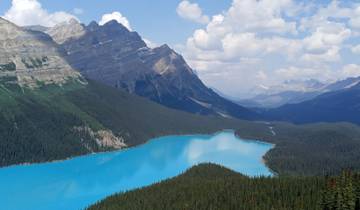 Panoramic view of a turquoise lake with a mountain backdrop.