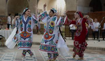 Colorfully dressed people dancing indoors.