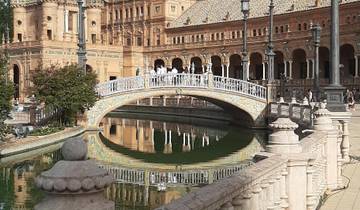 Ornate architecture and bridge with reflections on water.
