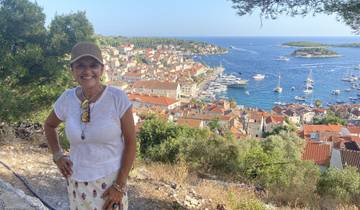 Woman posing in front of a coastal town with yachts.